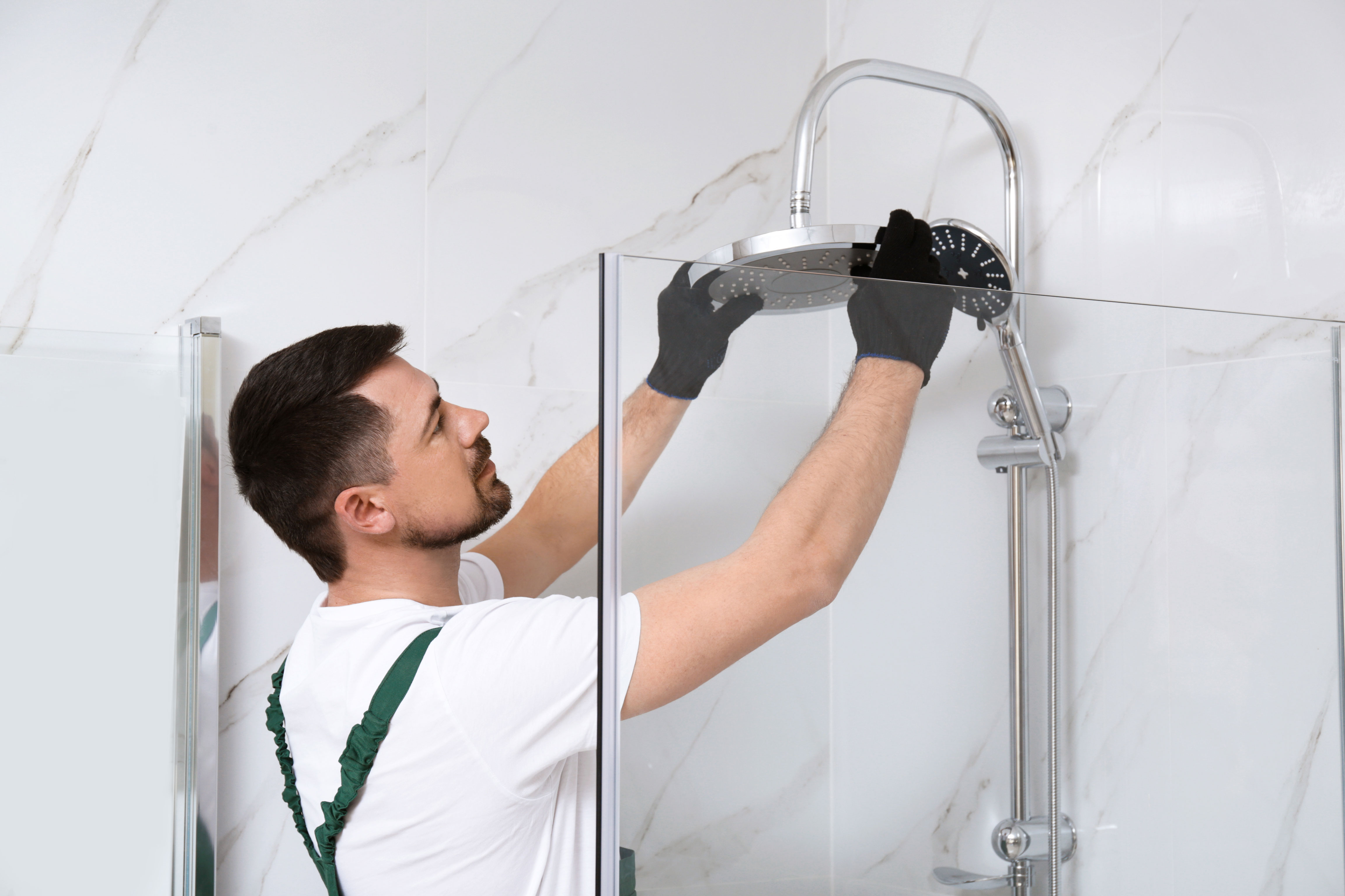 worker finishing installation of shower head
